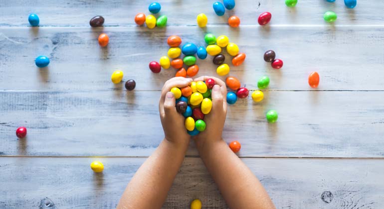 Barn med händerna fulla av färgglatt godis