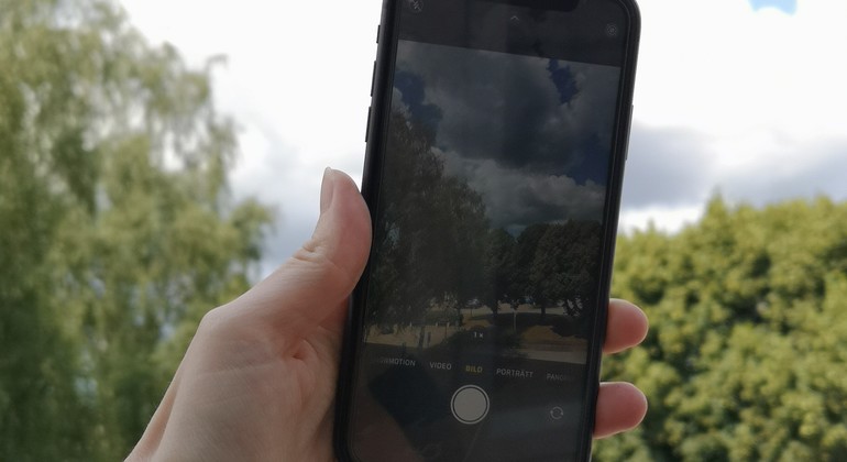 Person håller en iphone och ska kort