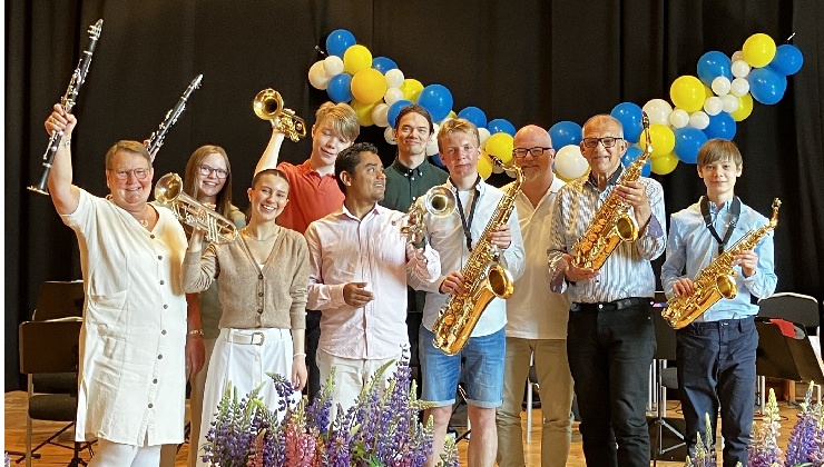 Ett antal personer som strå på en scen och håller i sina instrument