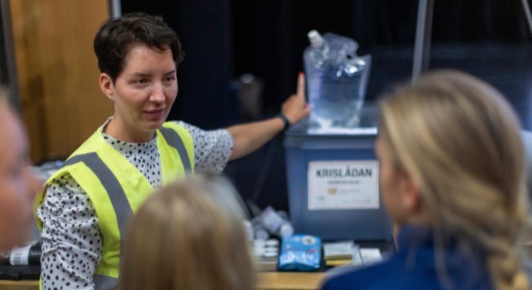 Kvinna som pekar mot en krislåda