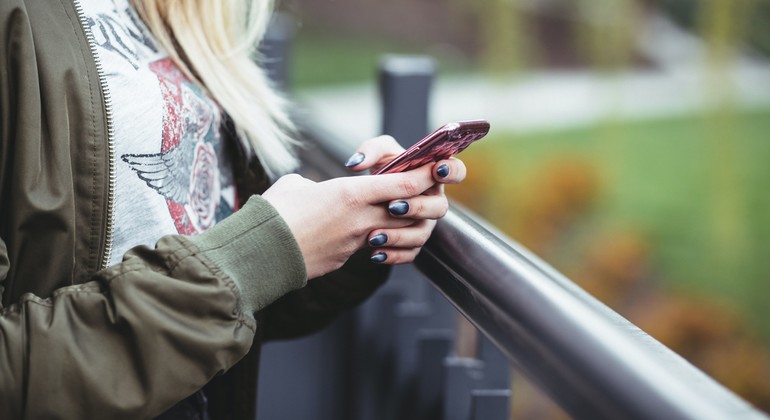 Person håller i en telefon utomhus