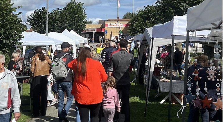 Människor promenerar bland marknadsstånd